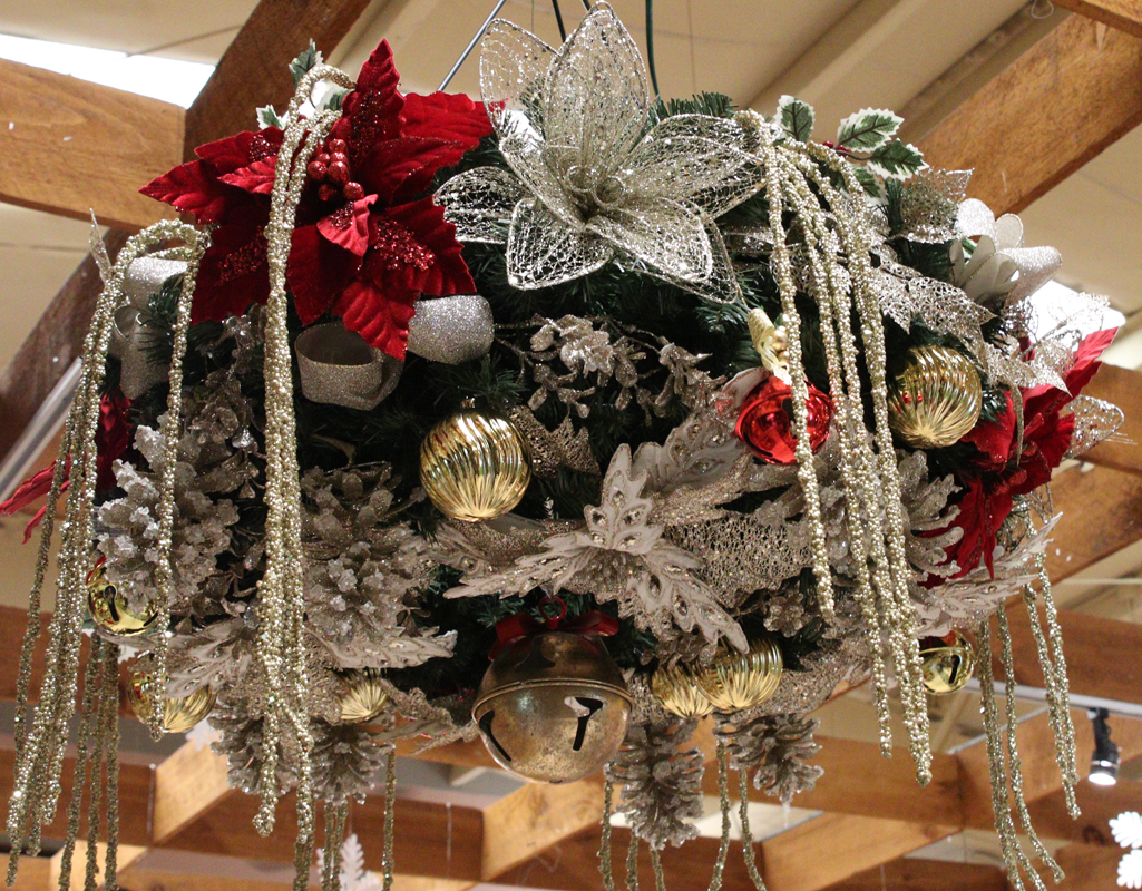 Hanging Christmas wreath decked out with ornaments, bows and flowers